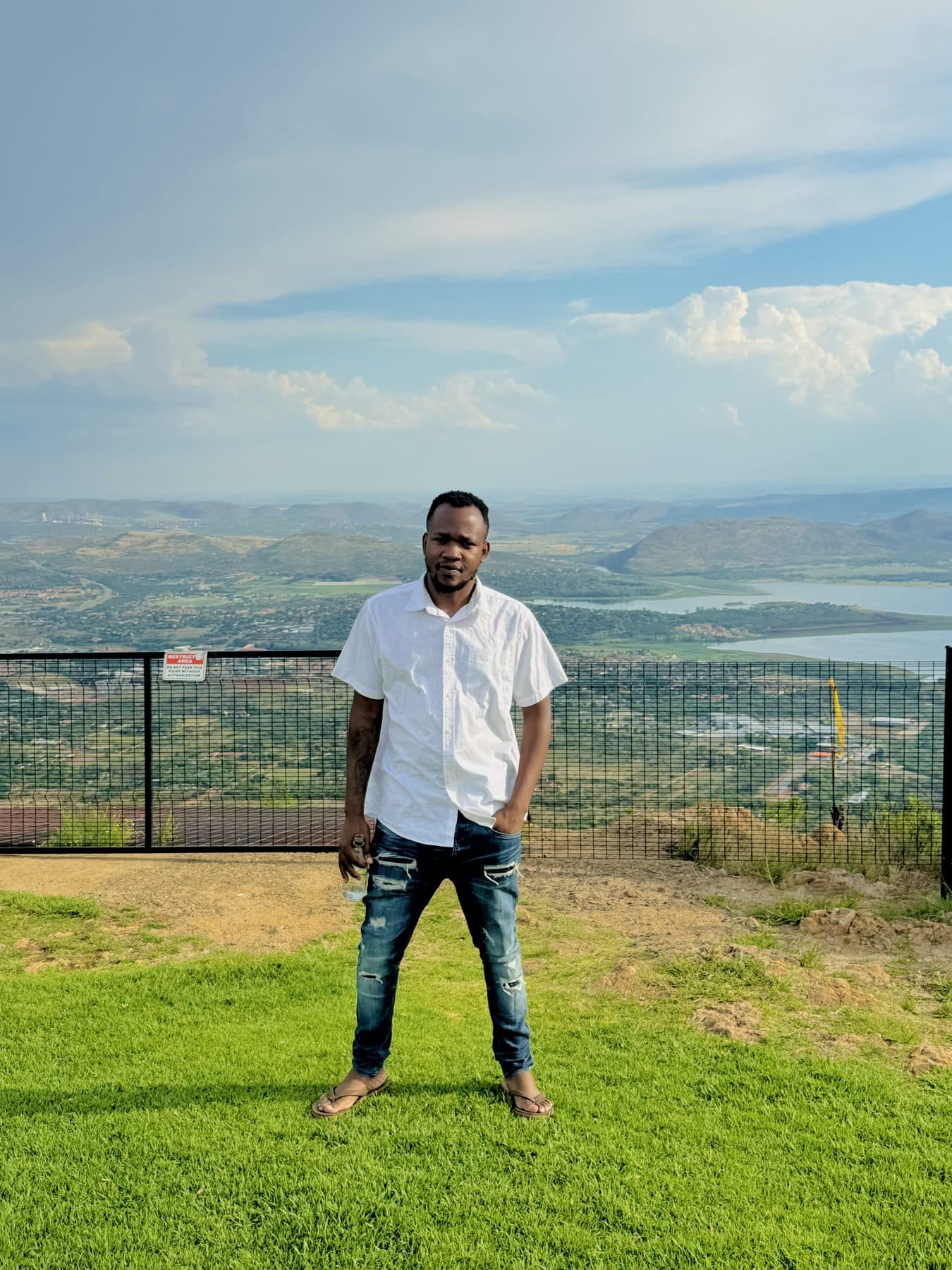 Crecias at a lookout above green hills and a dam